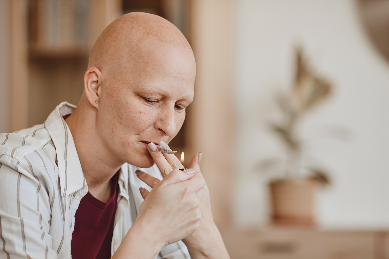 bald adult woman smoking marijuana joint for medicinal purposes in cancer recovery jpeg