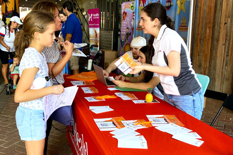 People approaching the table booth of Health eLifestyles Lab