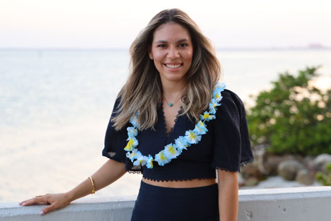 Diana Hernandez Payano smiling and standing by the ocean