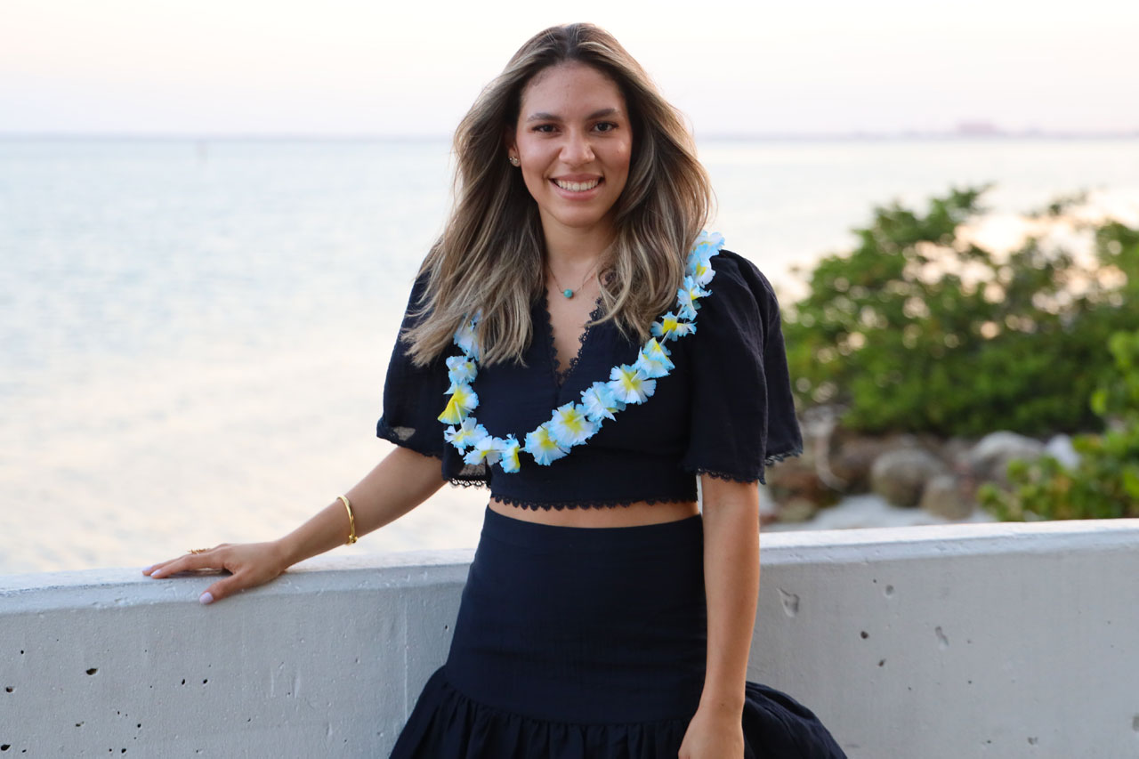 Diana Hernandez Payano smiling and standing by the ocean