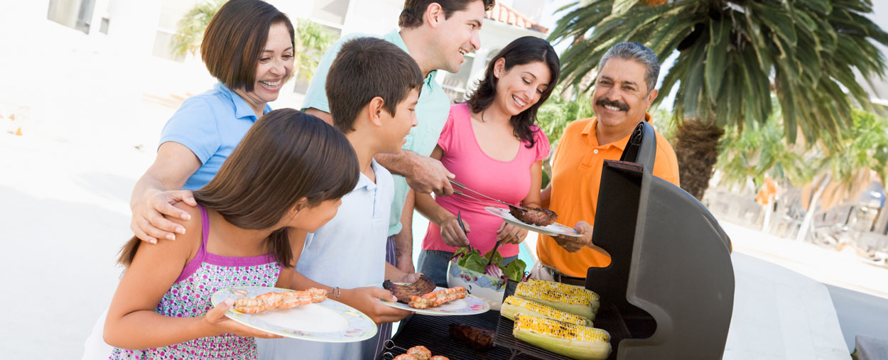 Family smiling by a BBQ grill 