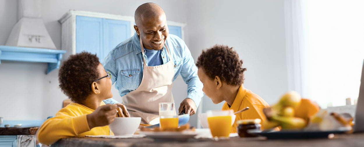 Father and sons eating at kitchen table