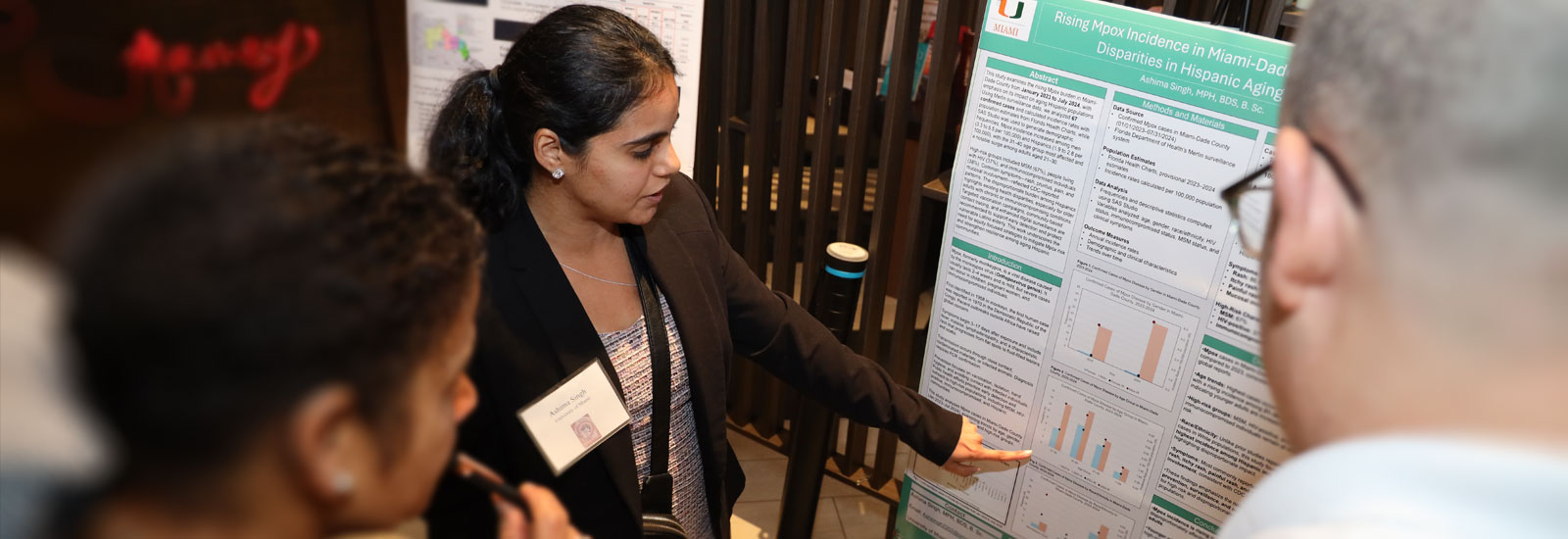 UM student showing graph studies on a poster