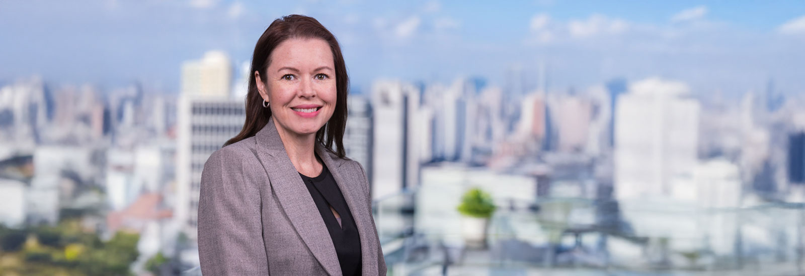 Portrait of Kathryn McCollister with a blur skyline background 