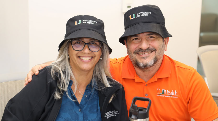 UM staff wearing matching hats and smiling together