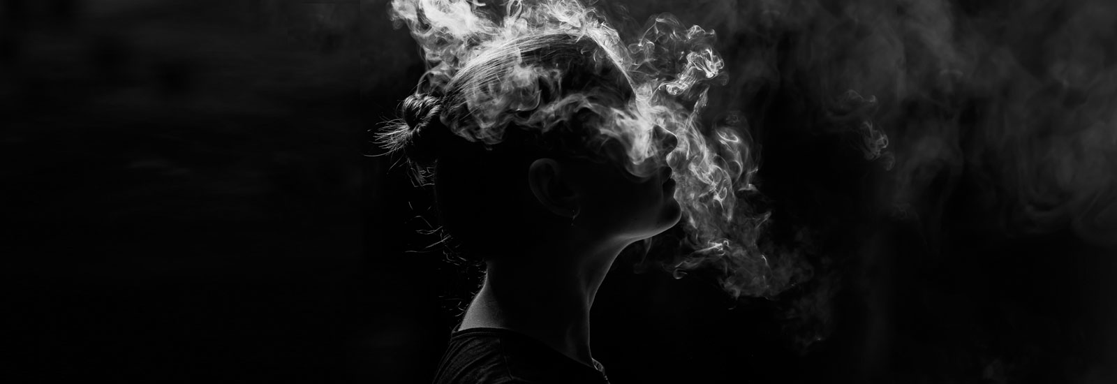 cloud of smoke surrounding a person's head