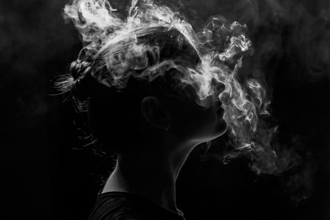 cloud of smoke surrounding a person's head