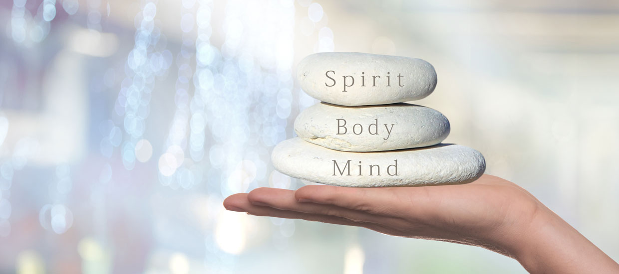 Rocks held by hand with message that reads "Spirit Body Mind"