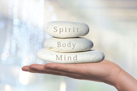 Rocks held by hand with message that reads "Spirit Body Mind"