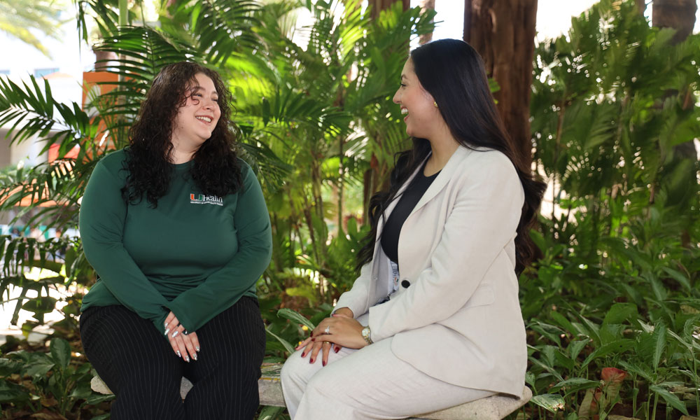 students sitting outdoors smiling
