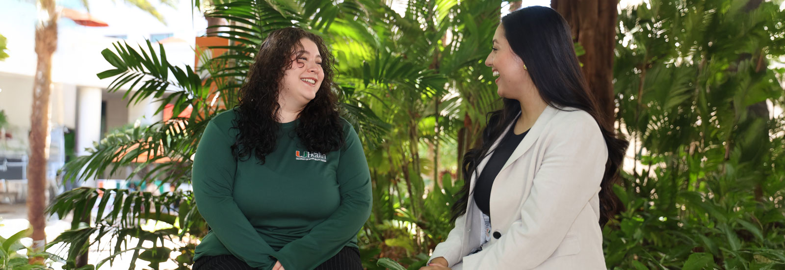 students sitting outdoors smiling