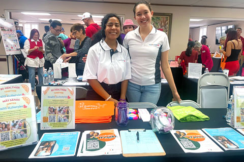 Members of Health eLifestyles Lab standing by their table booth