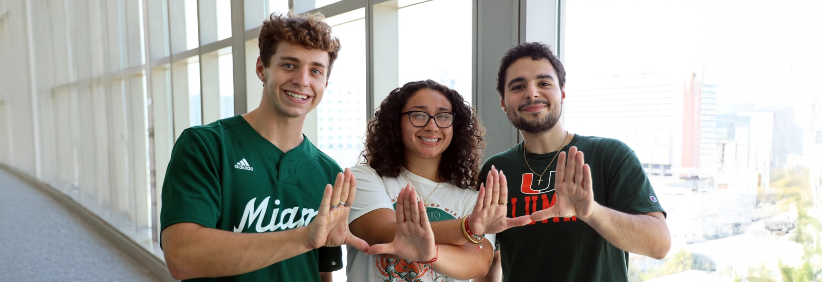 Students smiling and doing the U symbol with their hands